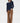 Woman wearing a navy sweater and brown pants on a white background