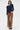 Woman wearing a navy sweater and brown pants on a white background